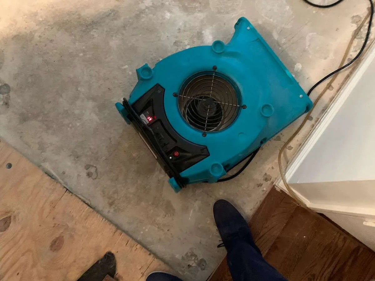 Air mover drying subfloor during Commercial Water Damage Restoration in Russellville